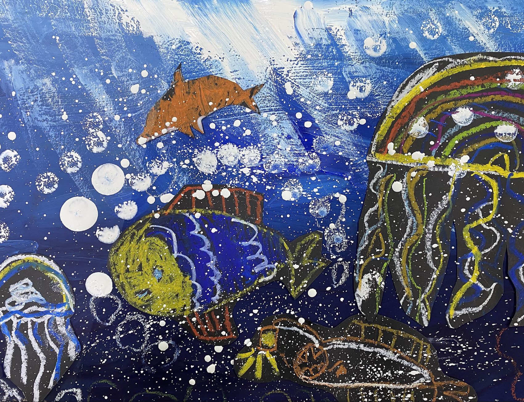 Deep blue underwater scene with falling light rays, a dolphin, a patterned fish and jellyfish trailing colourful streamers