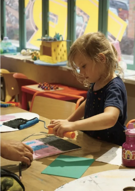 A child creating an artwork at a table