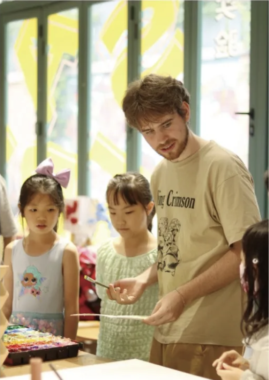 Young artists receiving guidance during an art activity