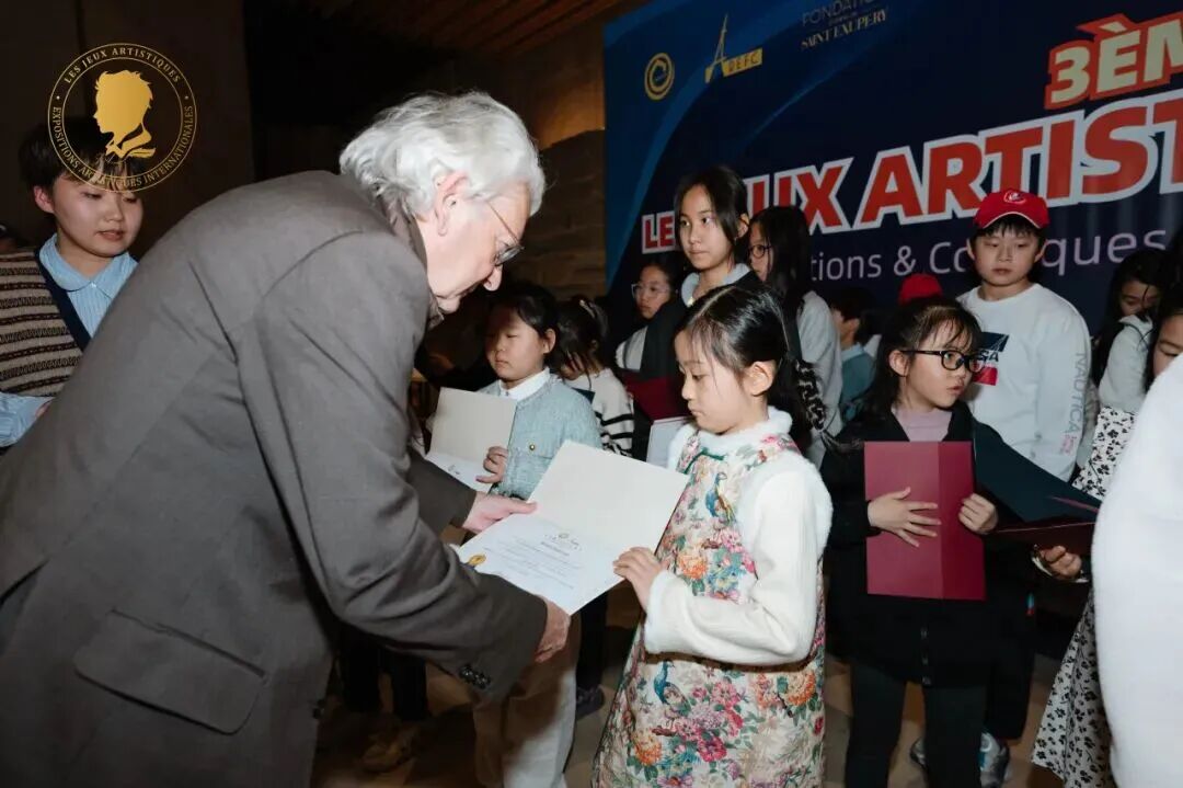 An exhibition guest presenting a certificate to a young artist